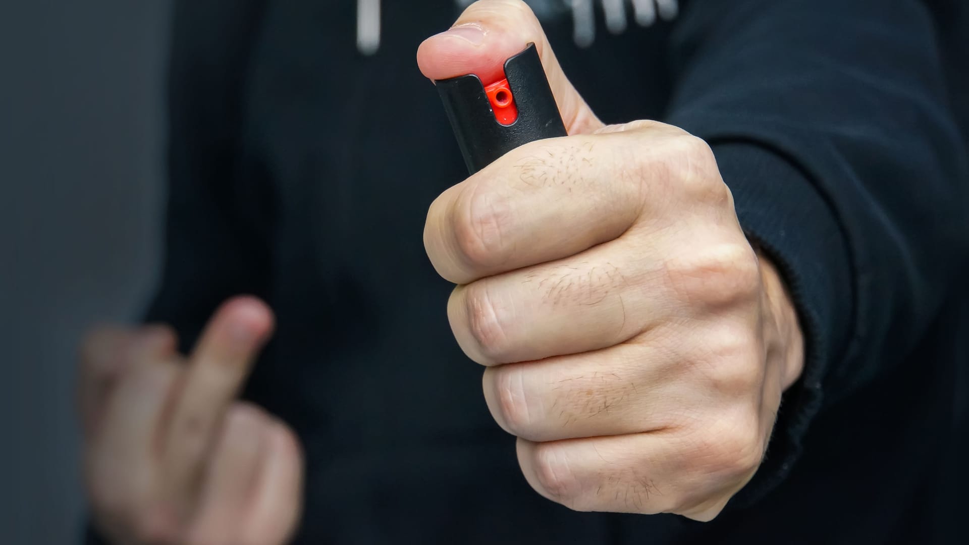 Hand with bottle of pepper spray