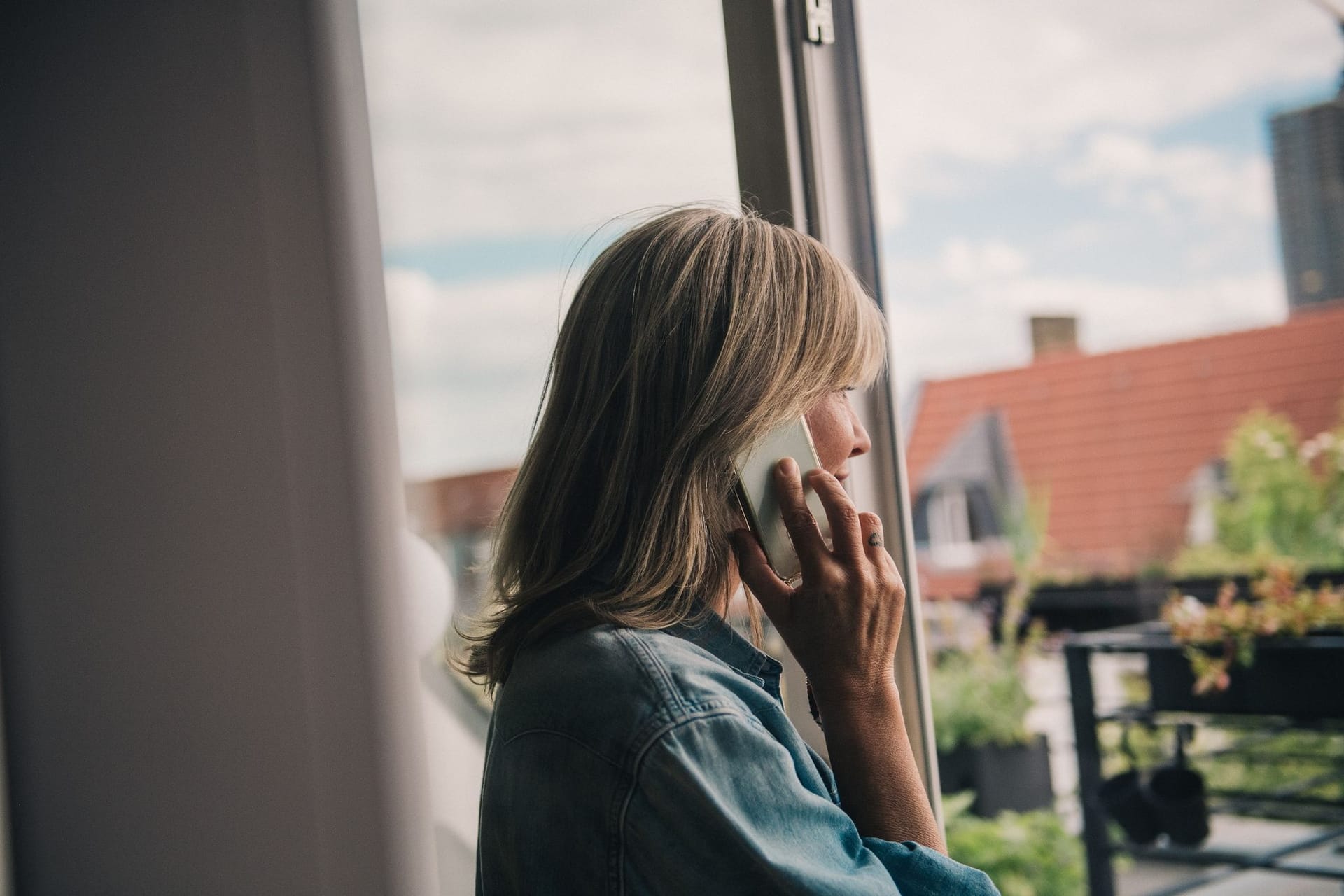 Eine Frau telefoniert am Fenster Eine Frau telefoniert am Fenster
