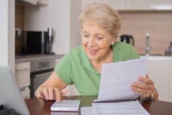 Ältere Frau rechnet: Die Witwenrente fällt ab Juli höher aus.
