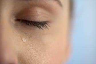 Frau mit Tränen im Auge: Häufig tränende Augen können beunruhigen. Was lässt sich gegen den Tränenfluss tun?