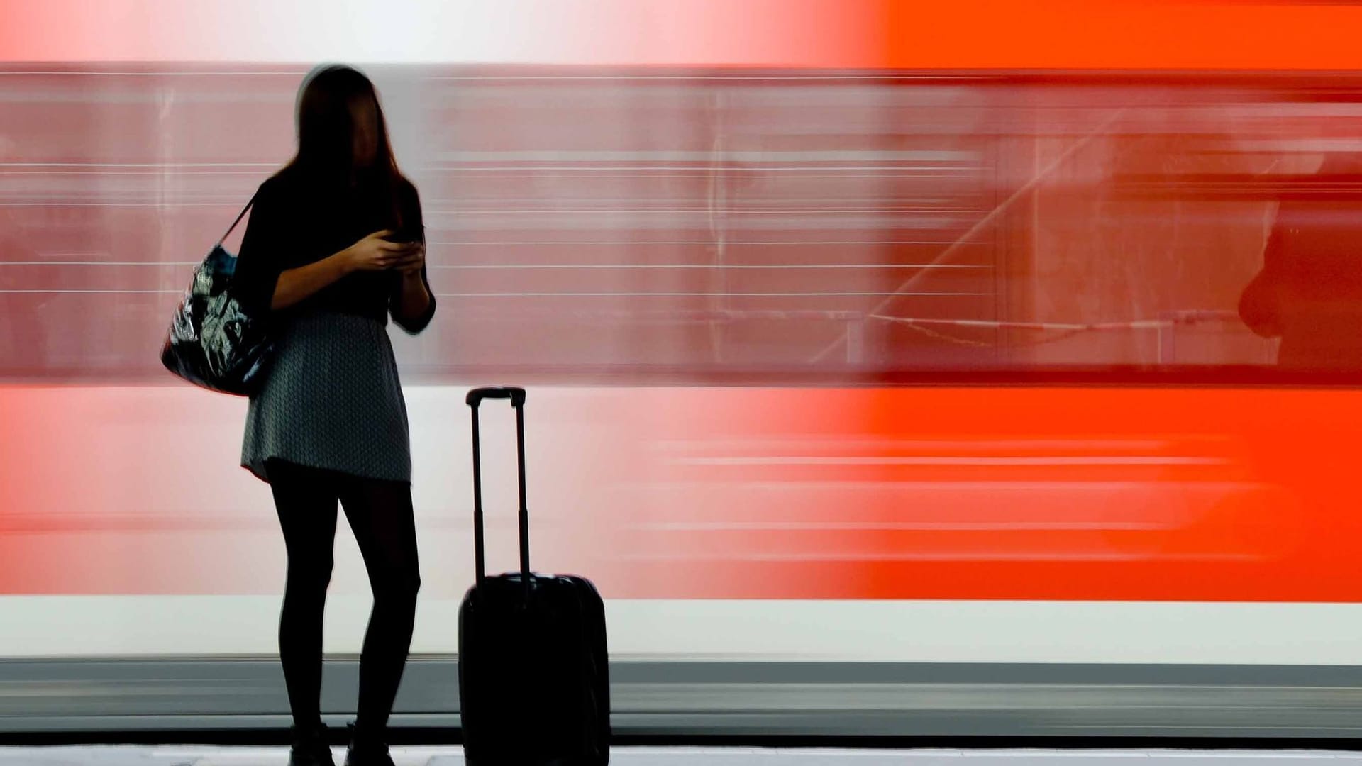 Eine junge Frau wartet auf einem Bahnsteig