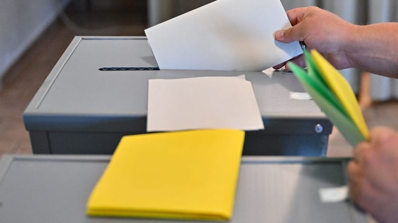 Eine Person steckt seinen Wahlzettel zu Europawahl in eine Wahlurne