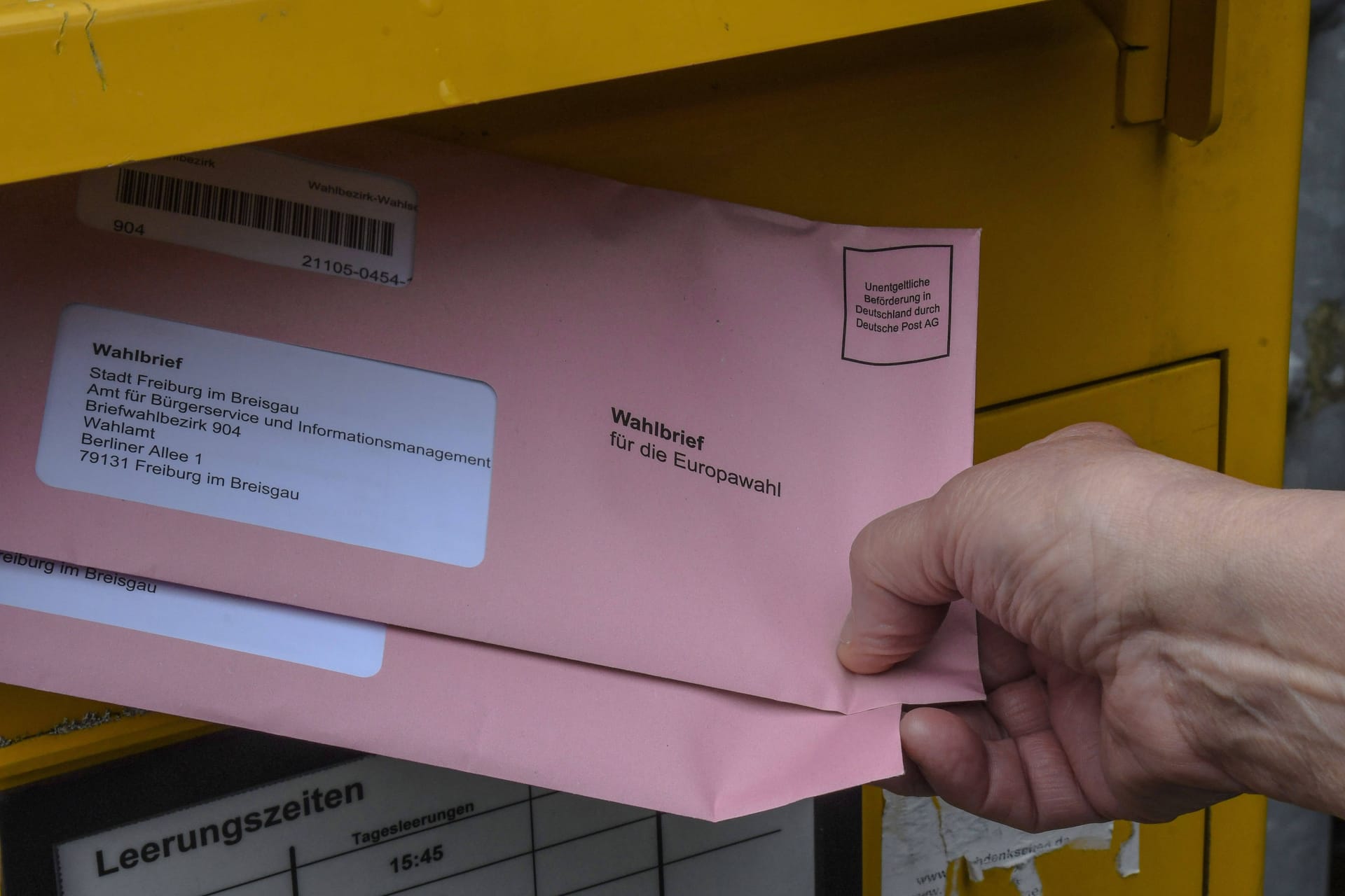 Eine Frau wirft Wahlbriefe zur Europawahl in einen Briefkasten (Symbolbild): In Köln sind bisher nur 53 Prozent der Briefwahlunterlagen zurückgesandt worden.