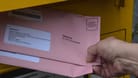 Eine Frau wirft Wahlbriefe zur Europawahl in einen Briefkasten (Symbolbild): In Köln sind bisher nur 53 Prozent der Briefwahlunterlagen zurückgesandt worden.