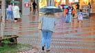 Menschen laufen bei Regen durch Essen (Archivbild): Am Montag und Dienstag sollten die Bewohner von NRW am besten immer einen Schirm zur Hand haben.