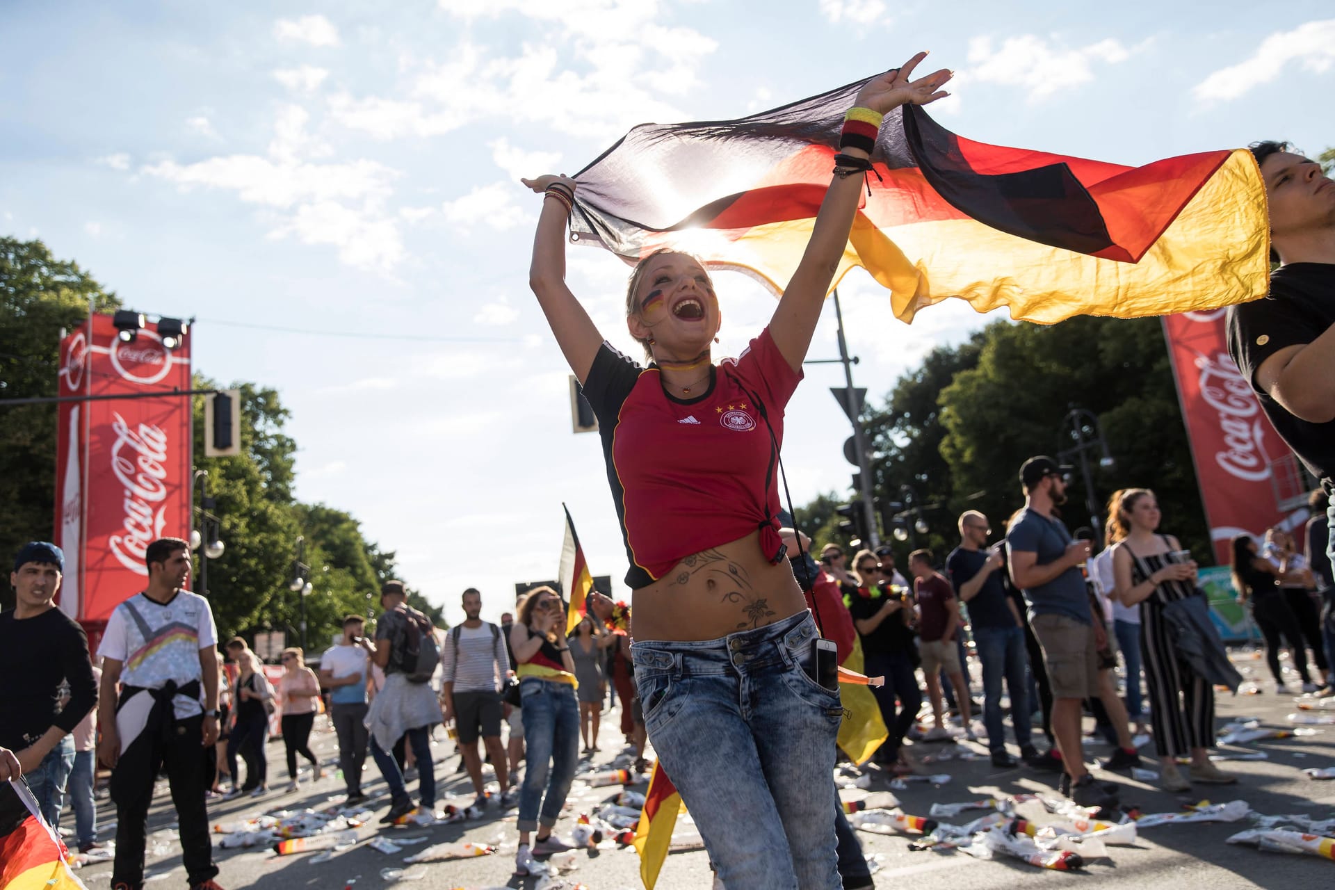 Frau mit Deutschlandfahne auf der Fanmeile auf der Strasse des 17. Juni am Brandenburger Tor (Archivbild): Jetzt wird es sommerlich-sonnig in den EM-Städten.