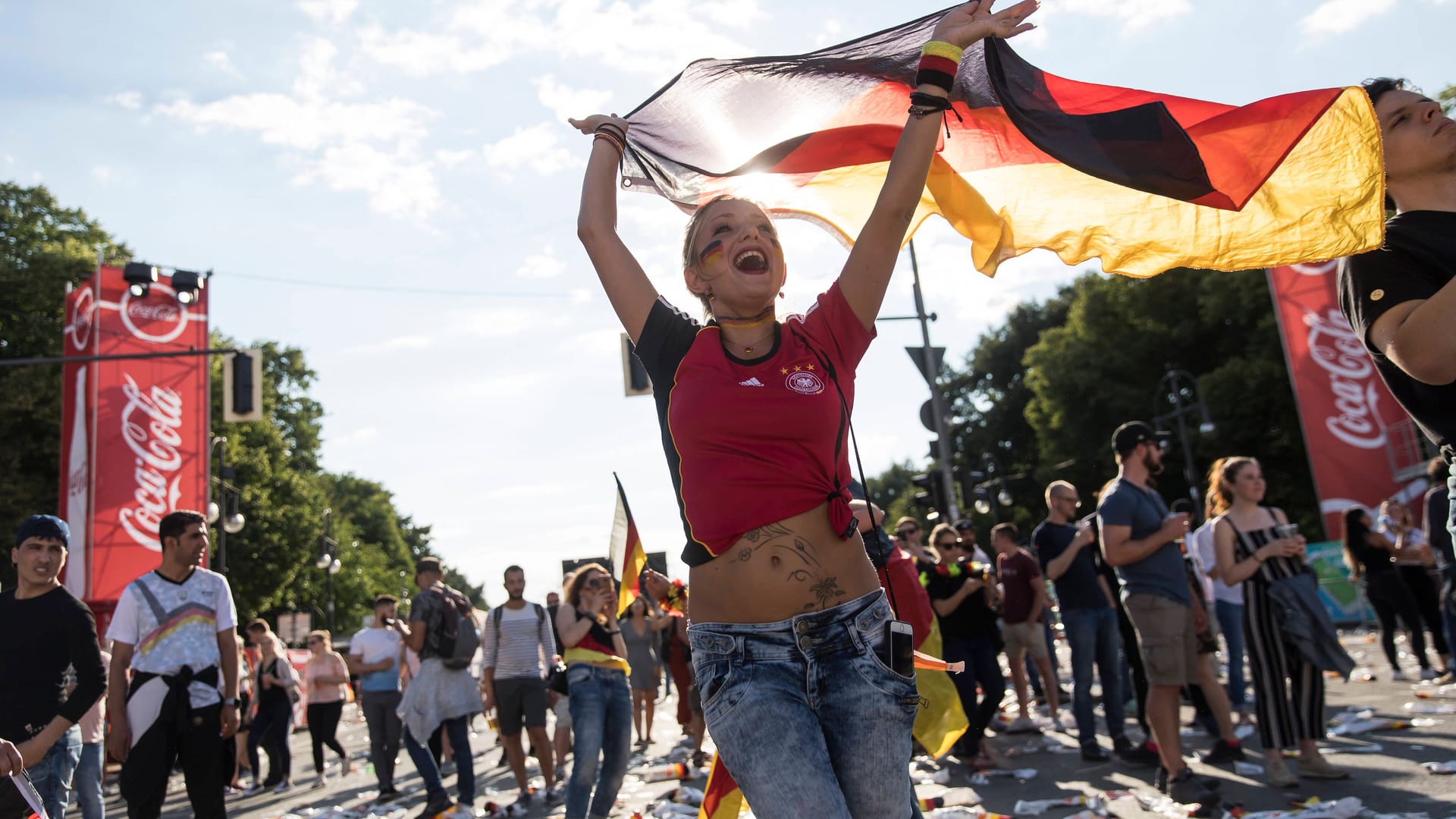 Frau mit Deutschlandfahne auf der Fanmeile auf der Strasse des 17. Juni am Brandenburger Tor (Archivbild): Jetzt wird es sommerlich-sonnig in den EM-Städten.