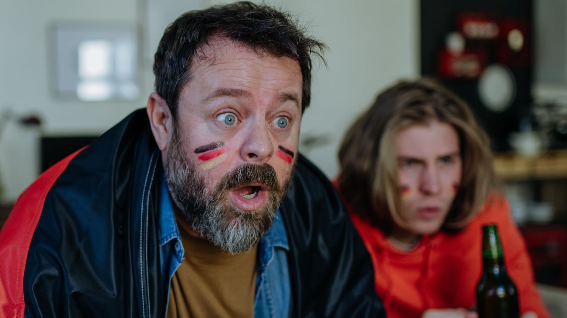 Nervous football fans friends staring at TV and watching football match at home