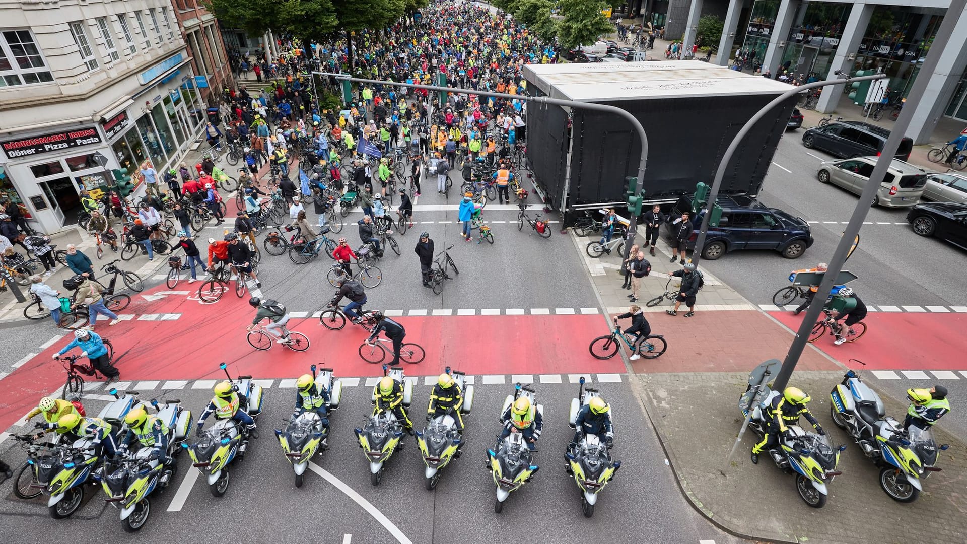 Radfahrer einer ADFC-Fahrrad-Sternfahrt stehen auf der Ludwig Erhard-Straße.