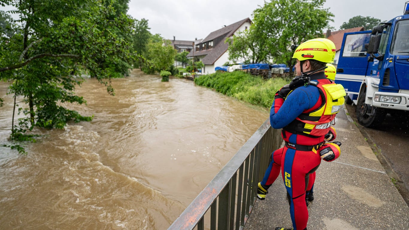 Ein Retter der DLRG blickt auf den angeschwollenen Fluss in Neu-Ulm: Im nahen Wald wurde eine junge Frau nach 52 Stunden lebend und unverletzt gefunden.