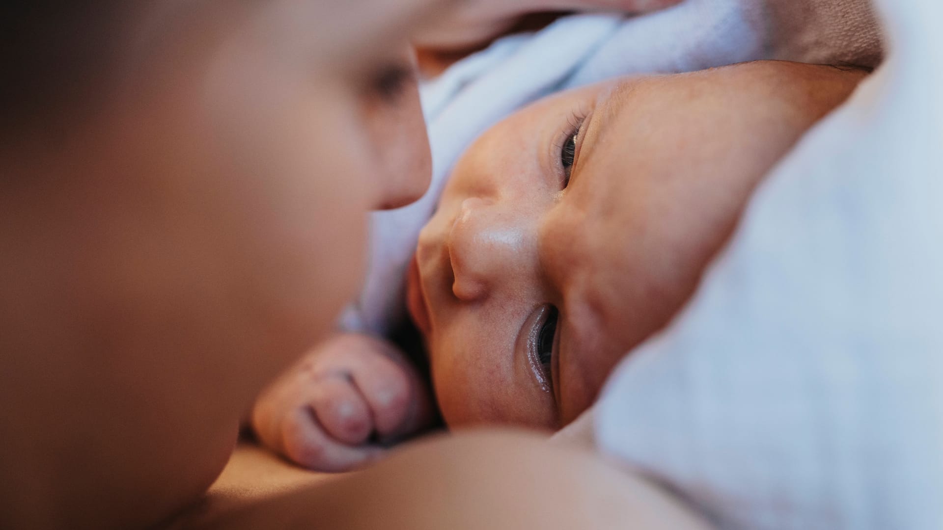 Eine Frau schaut ihr Baby an (Symbolbild): Mutter und Tochter sind wohlauf.