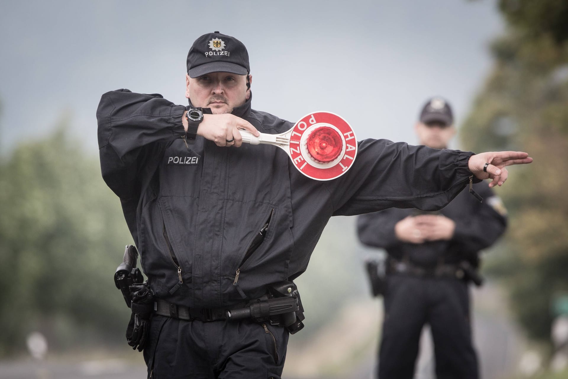 Ein Polizist winkt ein Auto zur Kontrolle heraus (Symbolbild):