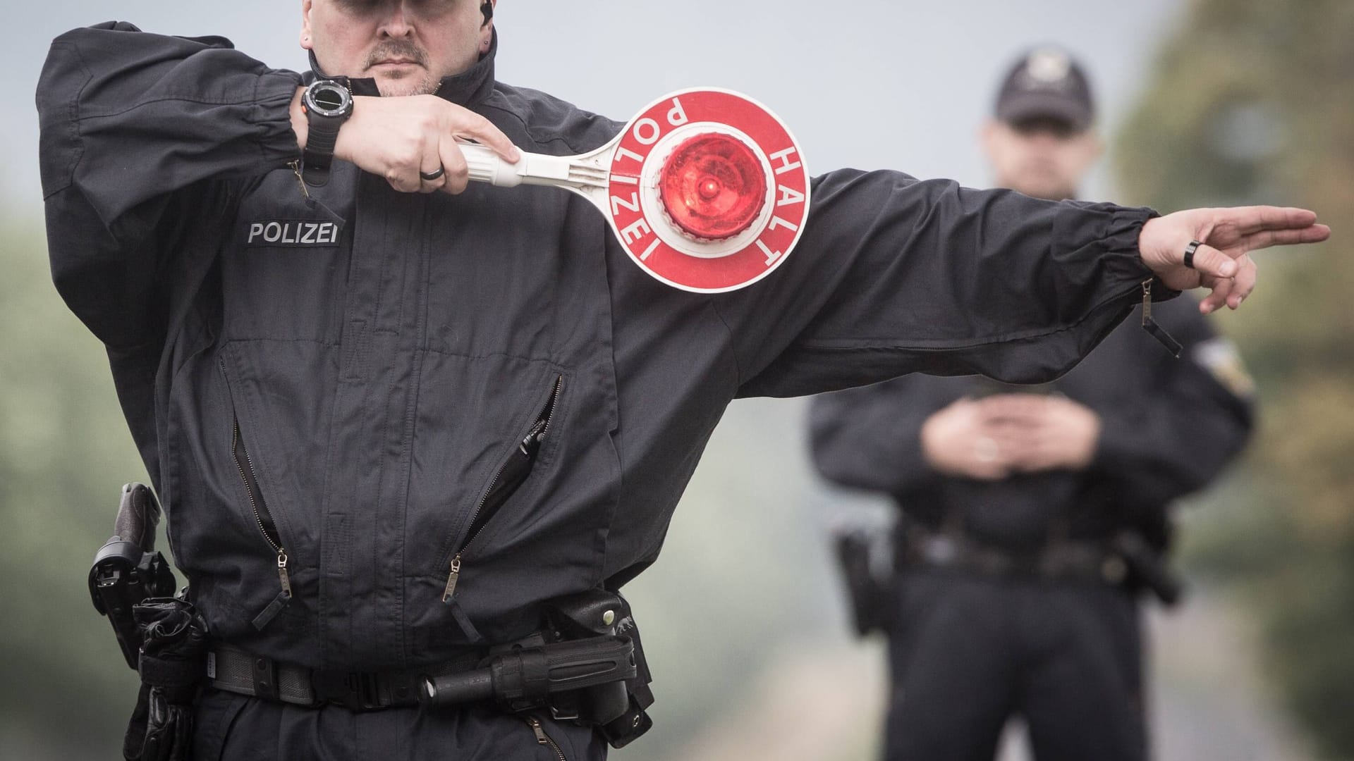 Ein Polizist winkt ein Auto zur Kontrolle heraus (Symbolbild): Ein Polizist winkt ein Auto zur Kontrolle heraus (Symbolbild):