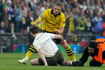 Eingegriffen: Dortmunds Sabitzer hilft dabei, einen Flitzer aufzuhalten.