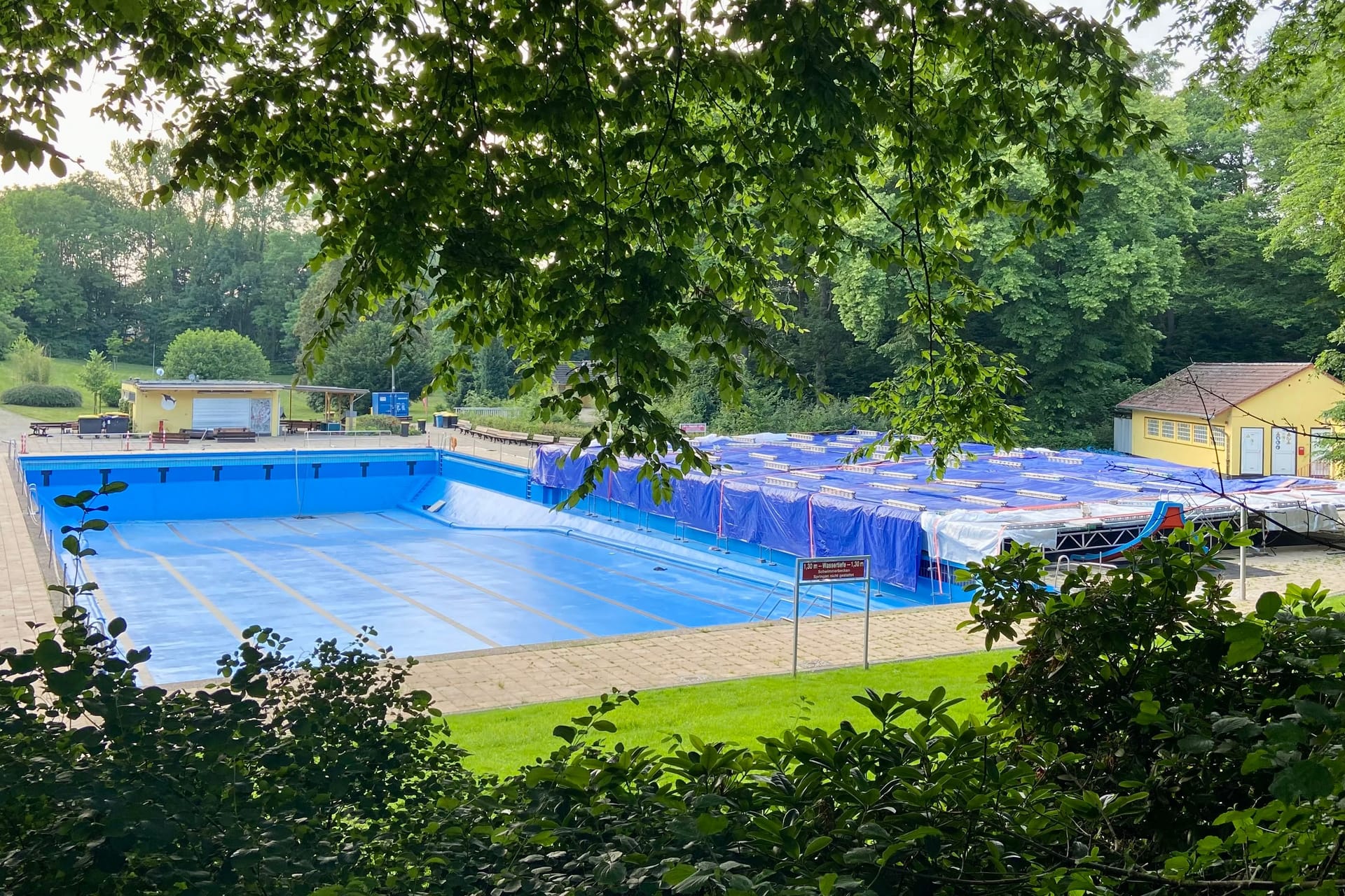 Die große Plane deckt das Nichtschwimmerbecken zurzeit noch komplett ab, auch im Schwimmerbecken fehlt noch das Wasser.