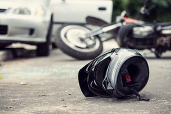 Ein Motorradhelm liegt nach einem Unfall auf dem Boden (Symbolbild): In Hamburg-Hammerbrook kam es zu einem schweren Verkehrsunfall.