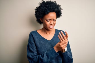 Frau mit Fingerschmerzen: Ein Schnappfinger erfordert in manchen Fällen eine OP.