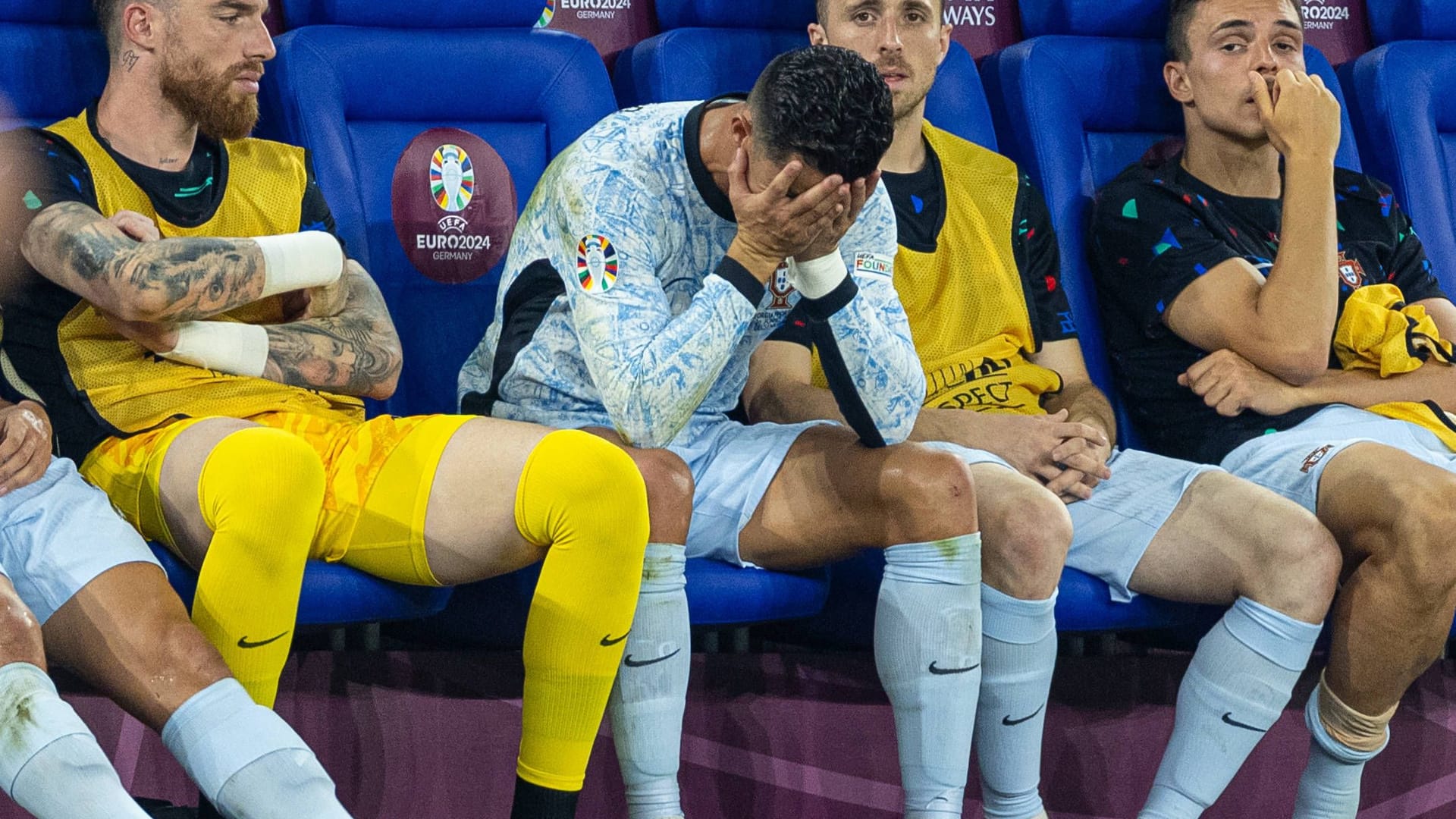 Cristiano Ronaldo (M.) hält sich nach seiner Auswechslung die Hände vors Gesicht.