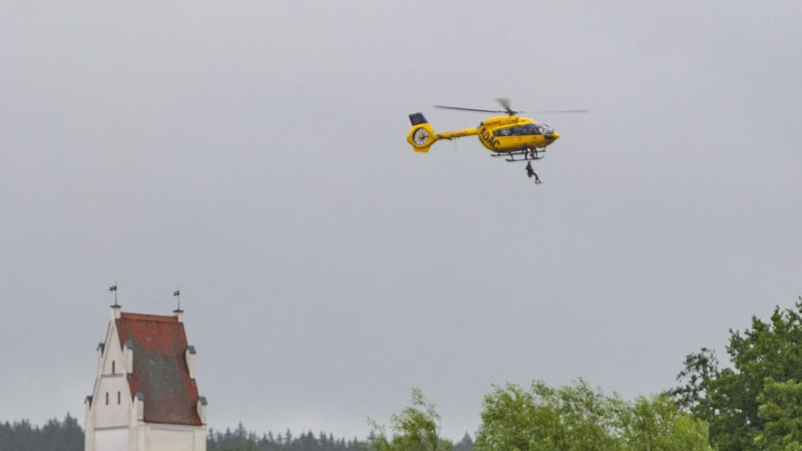 Menschen werden im Landkreis Augsburg in Schwaben mit einem Hubschrauber evakuiert.