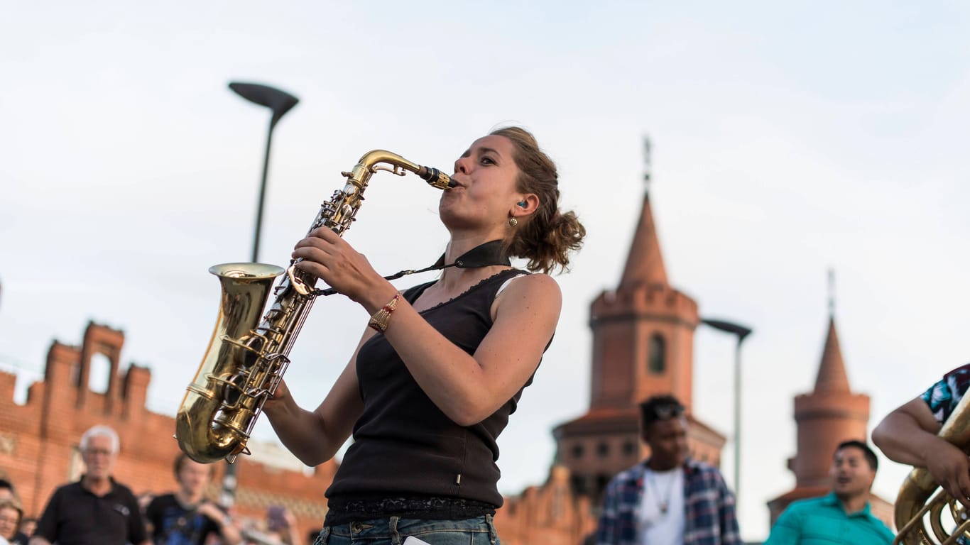 Saxophonistin spielt vor der Oberbaumbrücke (Archivbild): Zum Fête de la Musique sind in der ganzen Stadt kostenlose Aufritte.