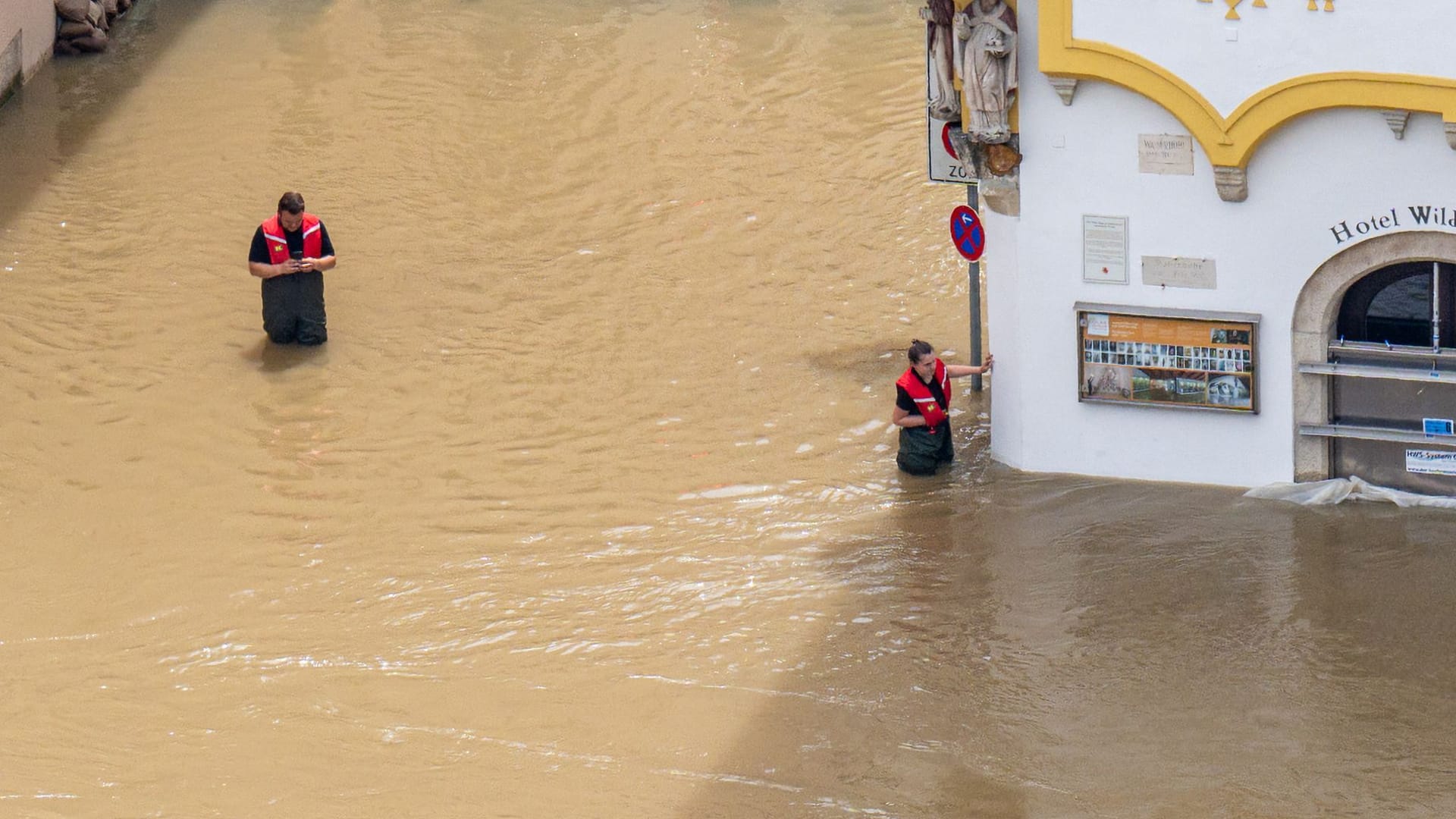 Rettungskräfte stehen im Hochwasser der Donau in Passau.