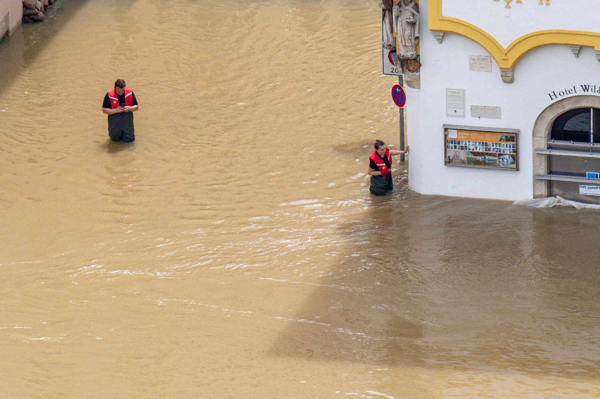 Rettungskräfte stehen im Hochwasser der Donau in Passau.