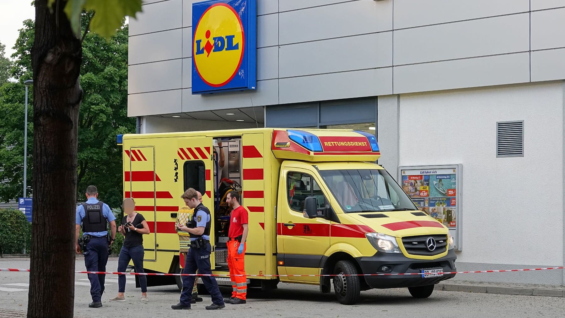 Einsatzkräfte an der Karl-Marx-Straße am Donnerstagabend: Zwei Lidl-Mitarbeiter wurden in eine Klinik gebracht.