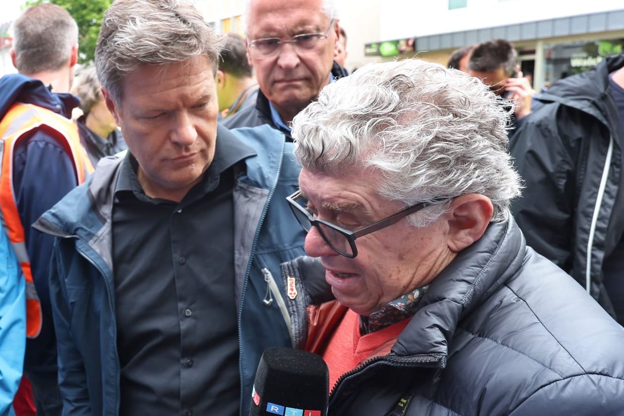 Söder und Habeck unterhalten sich mit einem vom Hochwasser betroffenen Eisdielenbesitzer.