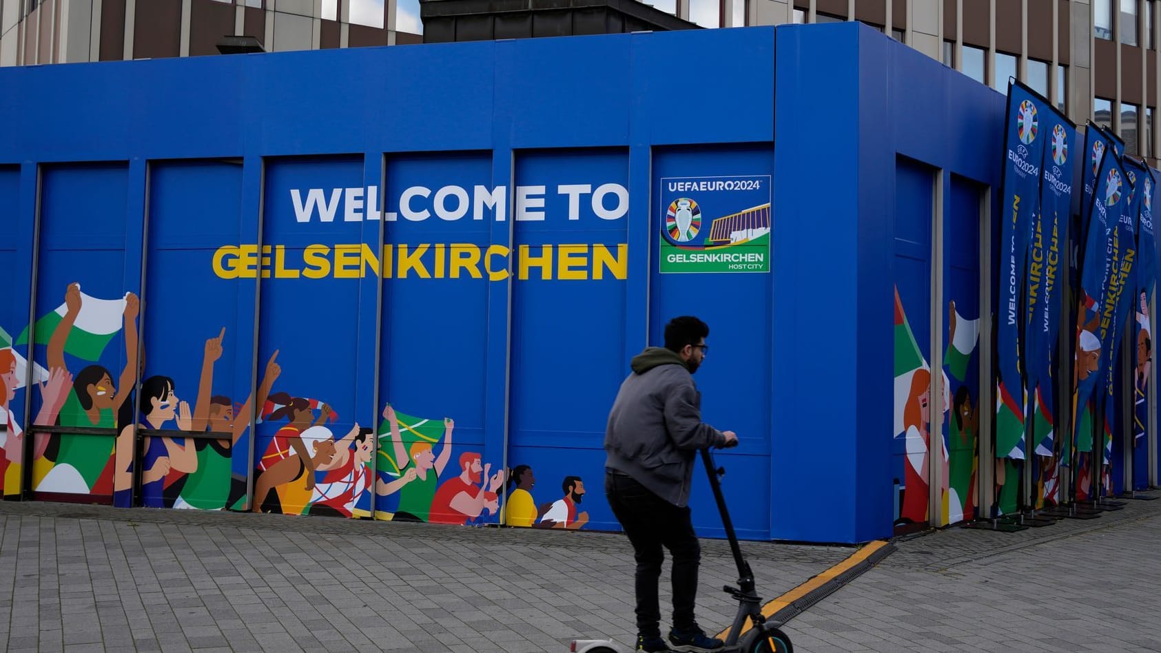 Ein Mann fährt mit dem Elektroroller am Gelsenkirchener Heinrich-König-Platz entlang: Die Stadt im Ruhrpott richtet das erste EM-Spiel Englands aus.