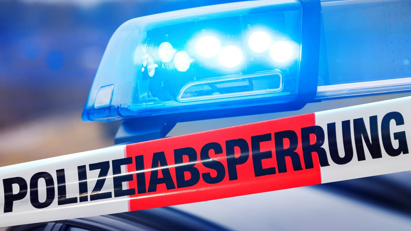 Absperrband vor einem Polizei-Einsatzfahrzeug mit hellem Blaulicht (Symbolbild): Ein Bekannter hatte den Mann gefunden.