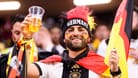 Ein Deutschland-Fan hält ein Bier in der Hand (Archivbild): Ab Freitag eröffnet die Fan Zone im Olympiapark.