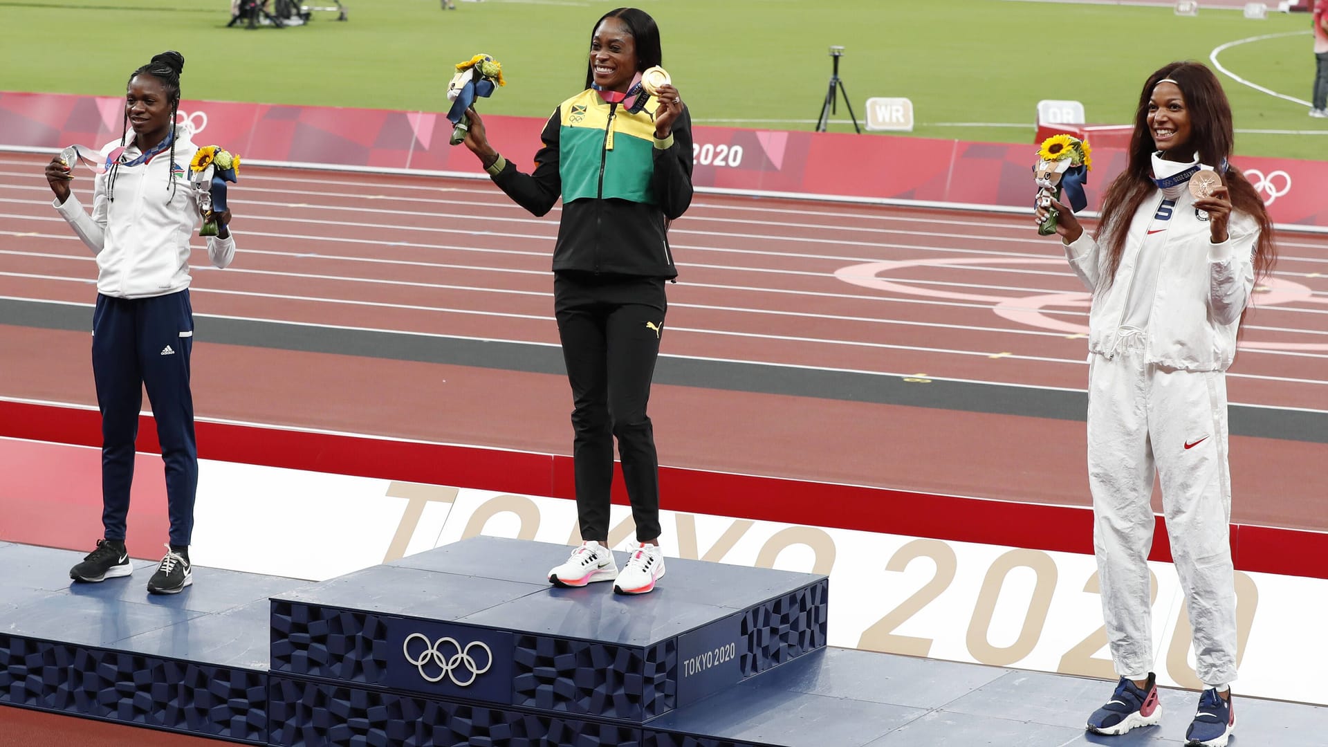 Elaine Thompson-Herah (m.) feiert eine ihrer Goldmedaillen in Tokio.