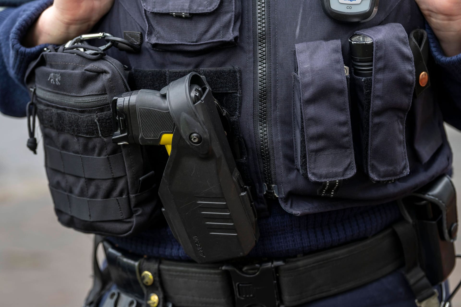 Diese Polizistin aus NRW hat schon einen Taser, der neben Erste-Hilfe-Pack, Taschenlampe und Handschellen an der Ausrüstungsweste befestigt ist.