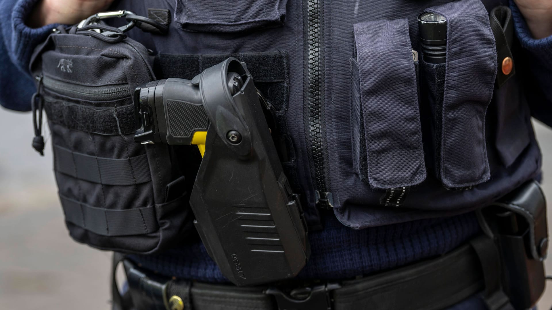 Diese Polizistin aus NRW hat schon einen Taser, der neben Erste-Hilfe-Pack, Taschenlampe und Handschellen an der Ausrüstungsweste befestigt ist.