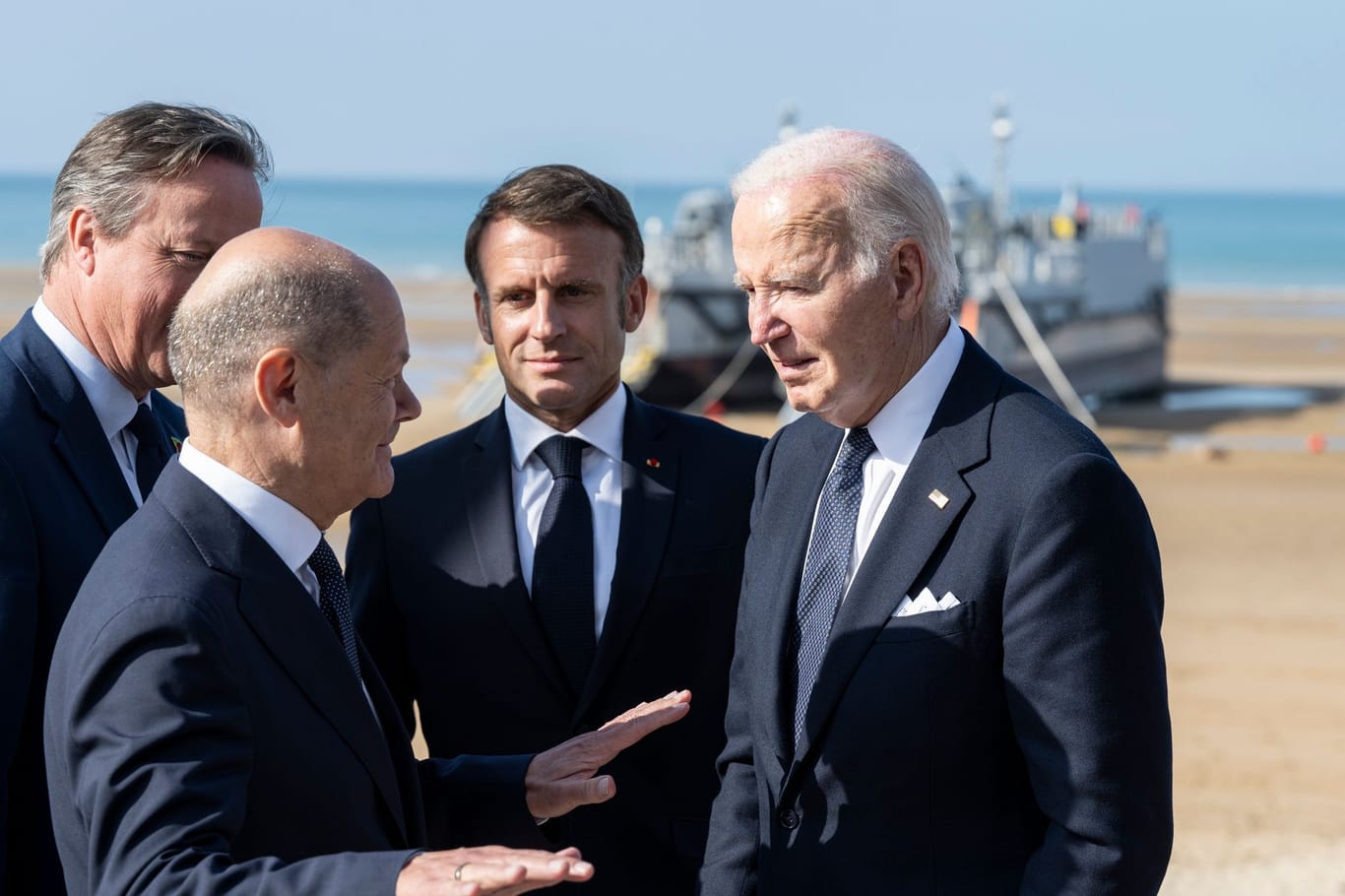Spitzenpolitiker David Cameron, Olaf Scholz, Emmanuel Macron, Joe Biden am Omaha Beach in der Normandie.
