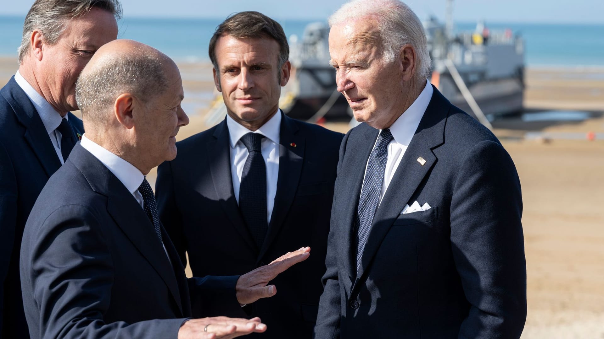 Spitzenpolitiker David Cameron, Olaf Scholz, Emmanuel Macron, Joe Biden am Omaha Beach in der Normandie.