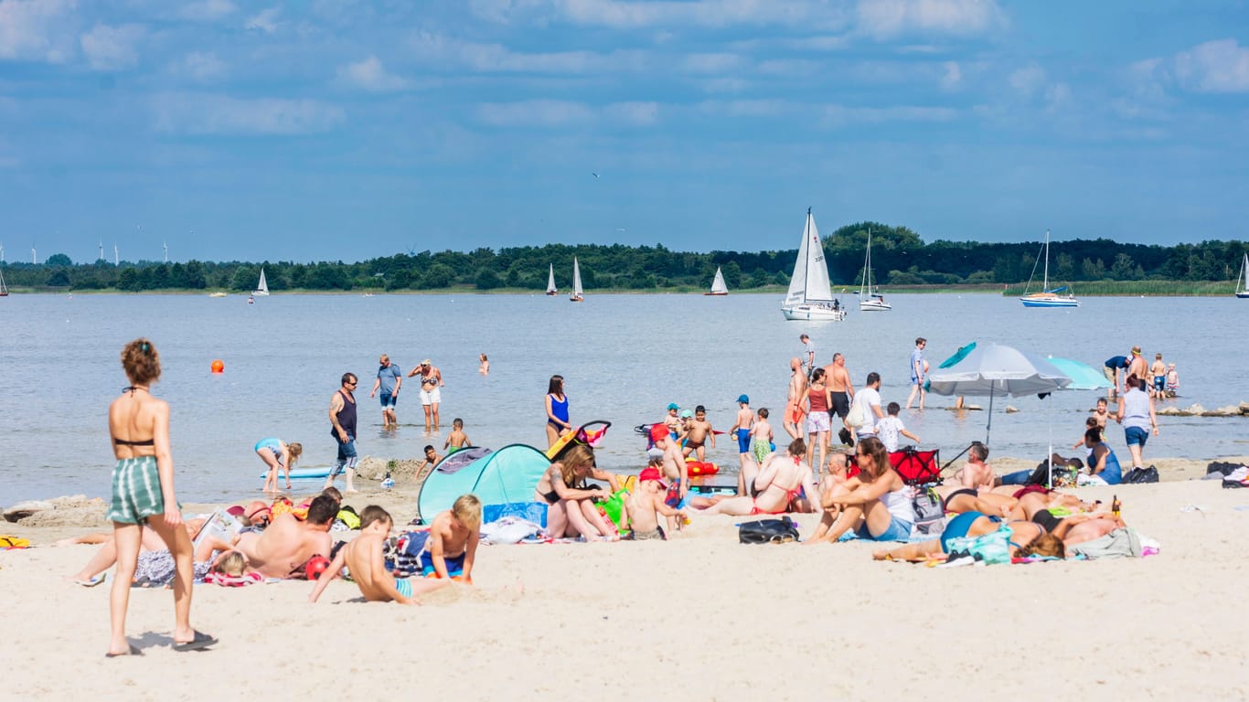 Menschen liegen am Strand am Steinhuder Meer: Bei schönem Wetter ist die Insel ein beliebter Badeort.