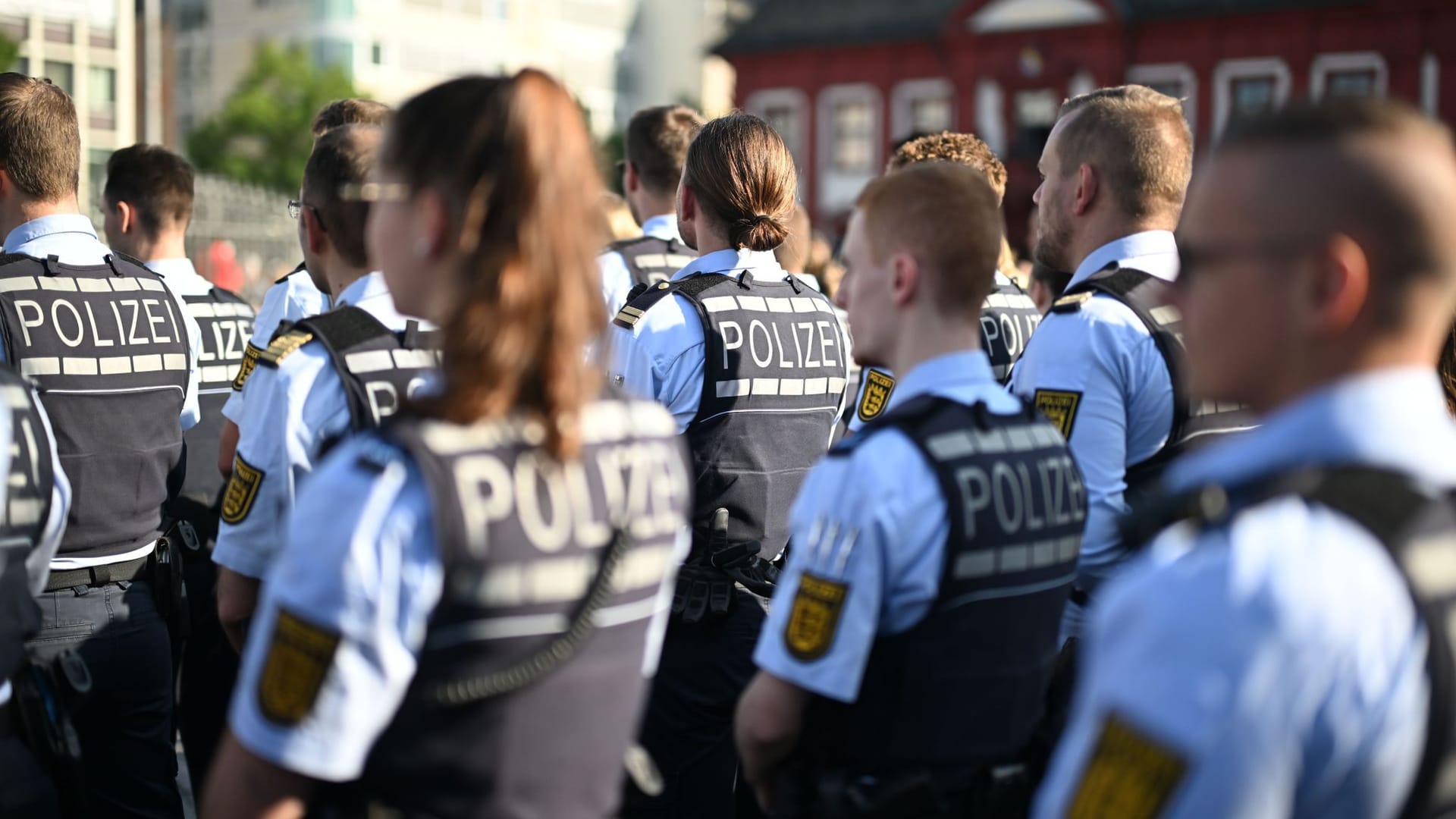 Bei einer Kundgebung unter dem Motto "Mannheim hält zusammen", die anlässlich einer Messerattacke stattfindet, bei der ein Polizist getötet wurde, stehen Polizisten am Marktplatz.