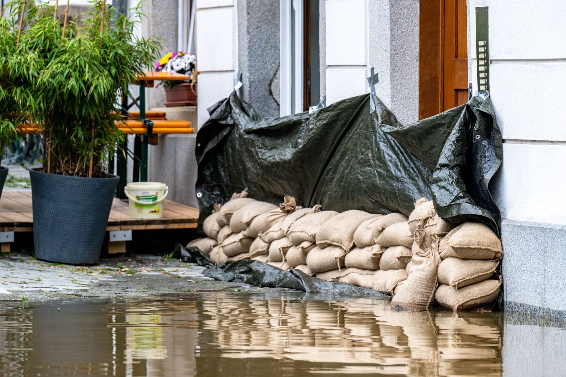 Rettungsversuch: Sandsäcke und Plane liegen vor einem Haus in Passau.