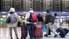 Passagiere stehen mit ihren Koffern vor einer Anzeigetafel im Flughafen (Symbolbild): FTI storniert alle Reisen.