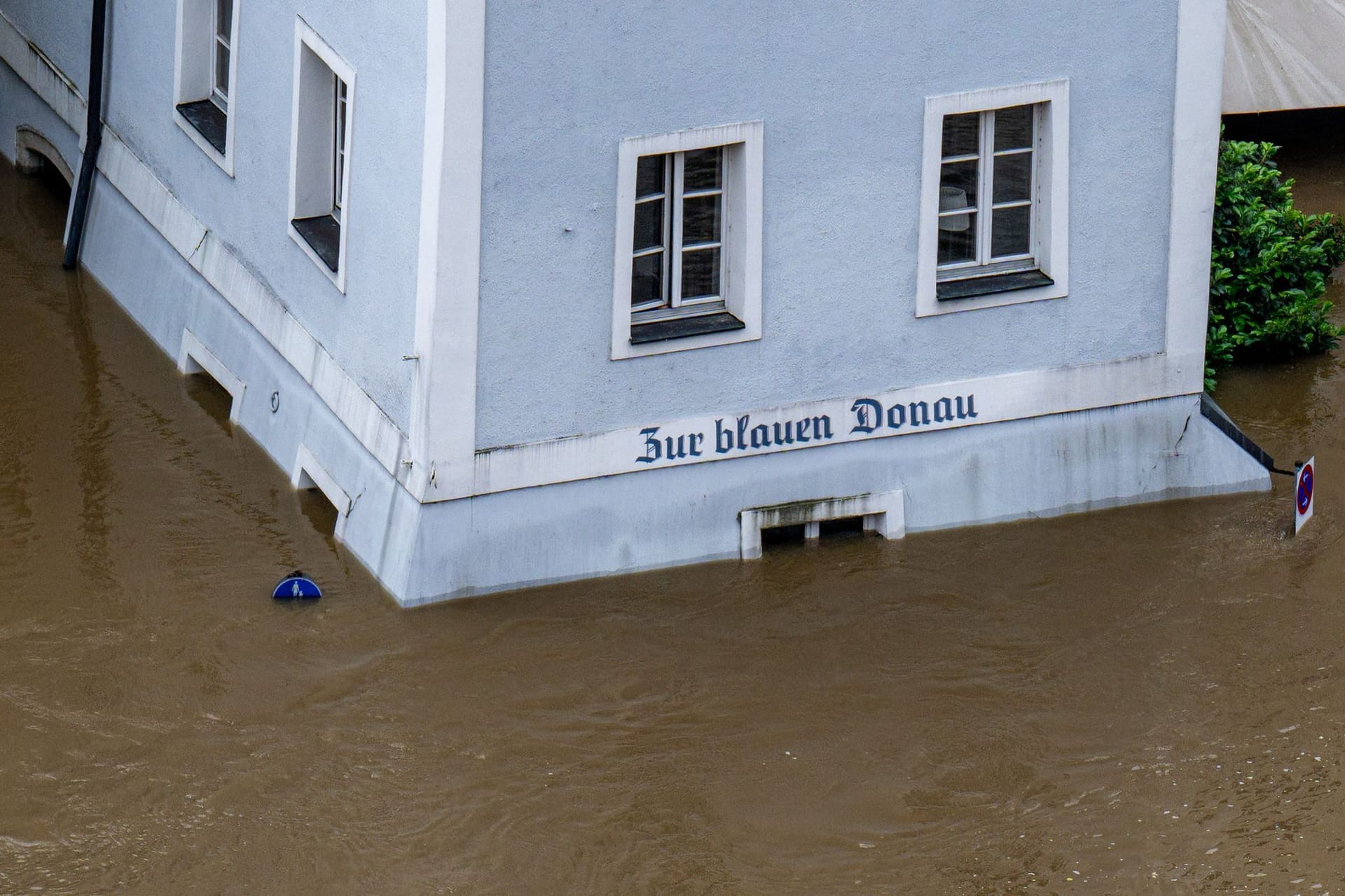 Wenn die malerische Donau-Lage zum Verhängnis wird: Ein Haus mit dem Schriftzug "Zur blauen Donau" steht im Hochwasser der Donau.