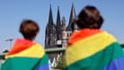 Teilnehmer mit Regenbogen-Fahnen vorm Kölner Dom beim Christopher Street Day 2022 (Symbolbild): Immer mehr Schülerinnen und Schüler berichten von queerfeindlichen Übergriffen an Schulen.