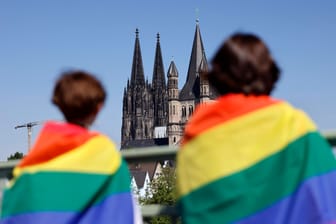 Teilnehmer mit Regenbogen-Fahnen vorm Kölner Dom beim Christopher Street Day 2022 (Symbolbild): Immer mehr Schülerinnen und Schüler berichten von queerfeindlichen Übergriffen an Schulen.