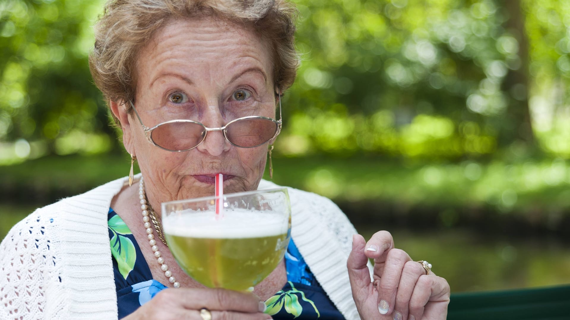 Ältere Dame trinkt Berliner Weisse.