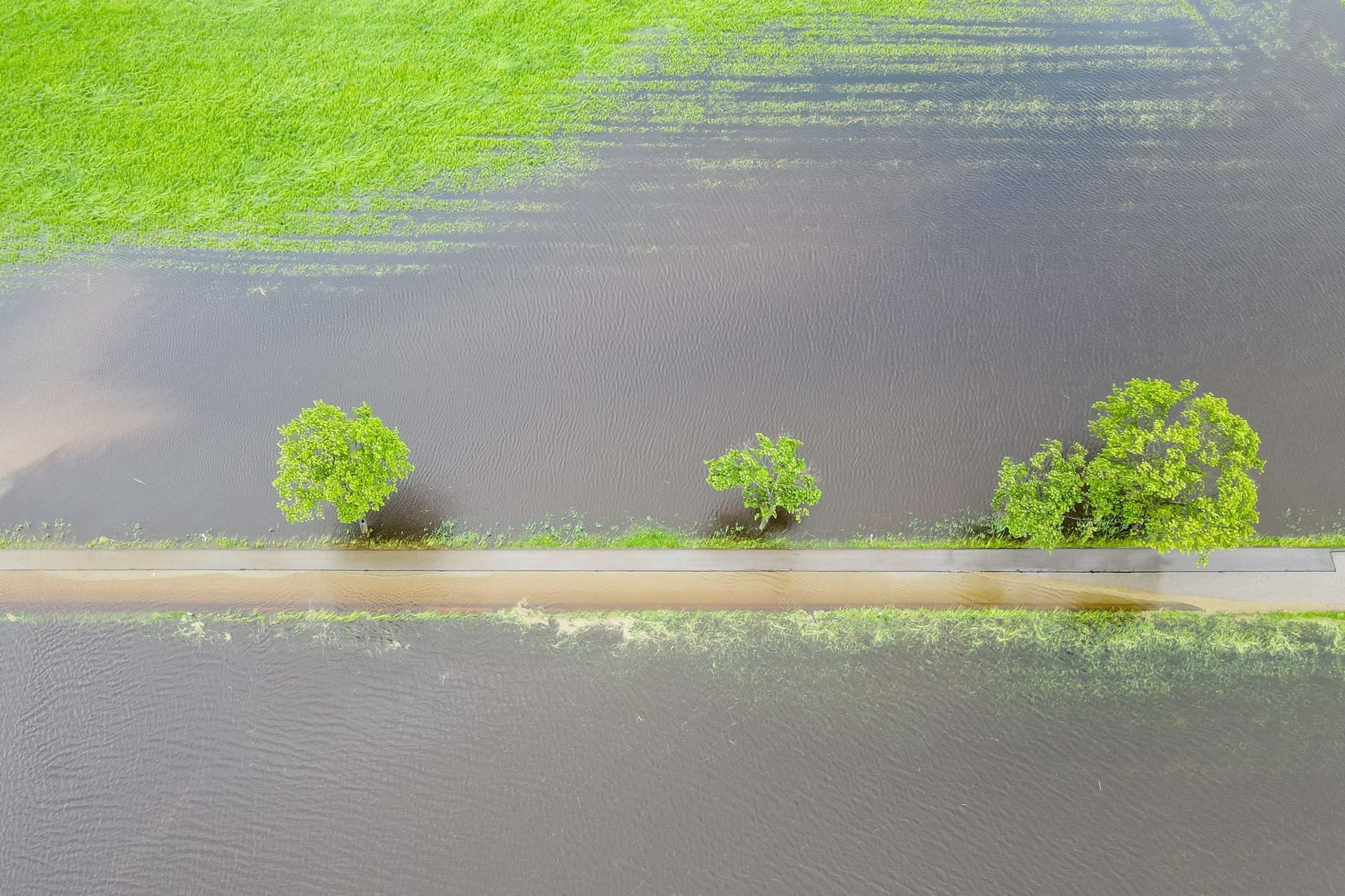 Bayern, Dinkelscherben: Ganze Wiesen und Felder sind nach den anhaltenden Regenfällen überschwemmt und haben sich zu großen Seen gebildet (Luftaufnahme mit einer Drohne).