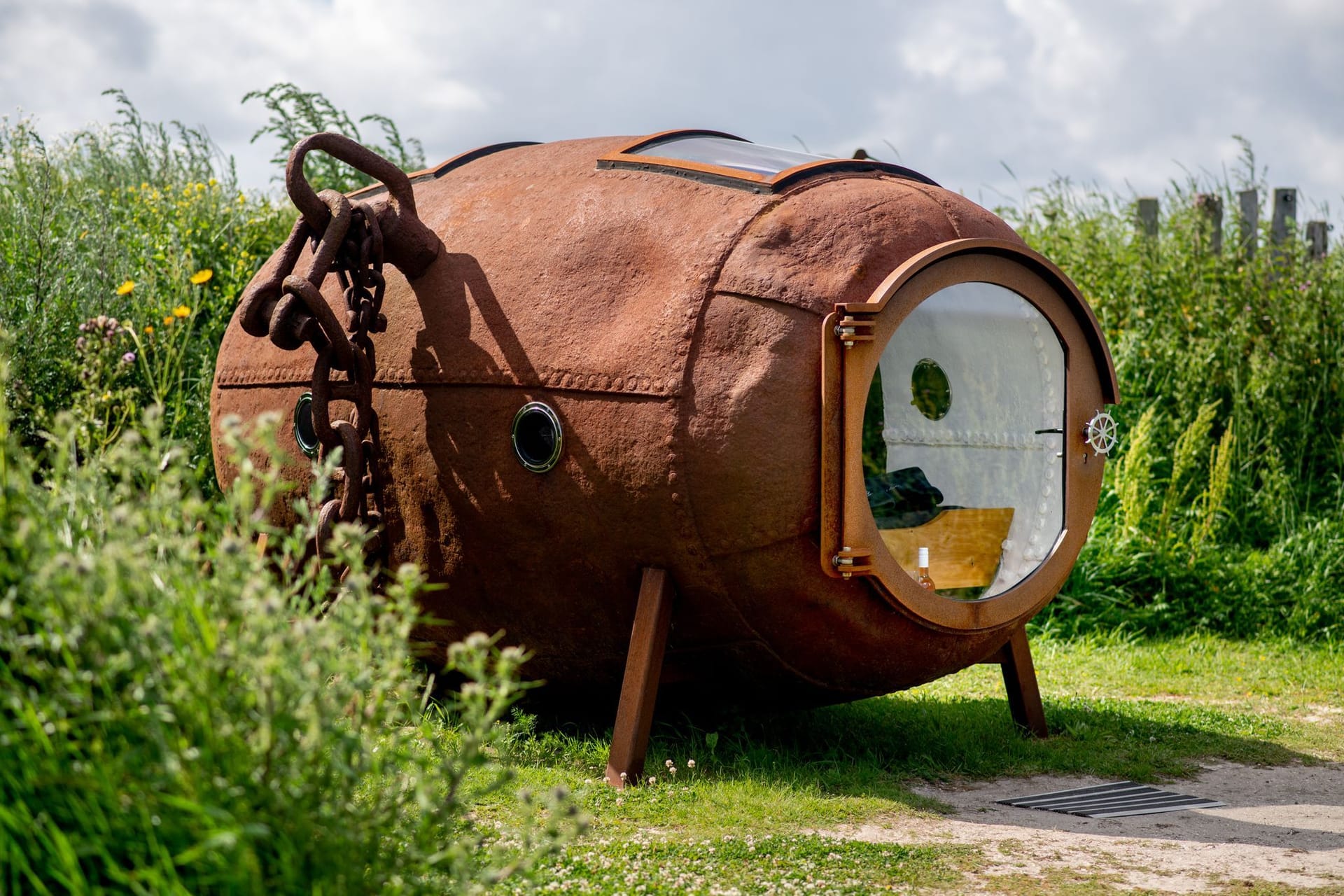 Eine ehemalige Ankerboje, in die ein Bett und eine Glastür sowie mehrere Fenster eingebaut wurden, steht in den Dünen bei Harlesiel an der Nordseeküste.