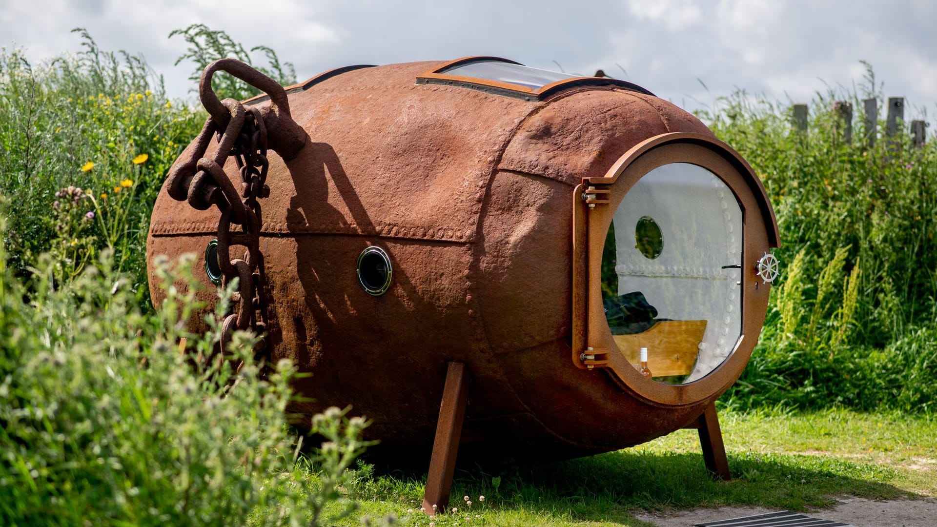 Eine ehemalige Ankerboje, in die ein Bett und eine Glastür sowie mehrere Fenster eingebaut wurden, steht in den Dünen bei Harlesiel an der Nordseeküste.