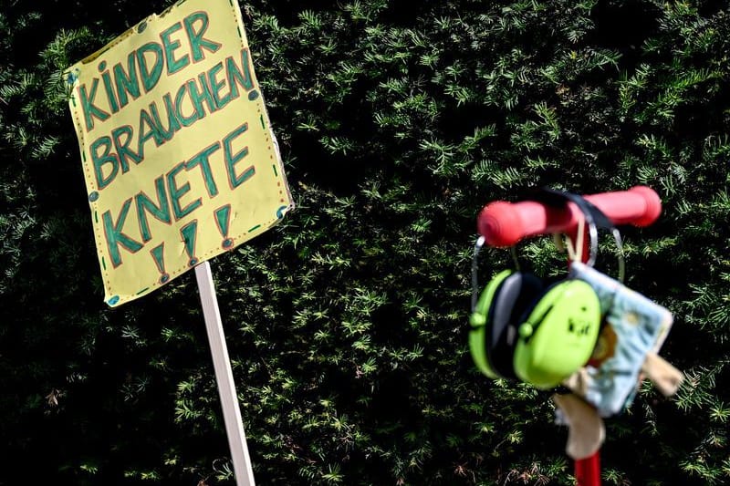 Vor dem Berliner Abgeordnetenhaus steht ein Schild mit der Aufschrift "Kinder brauchen Knete" bei der Kundgebung streikender Kita-Erzieherinnen