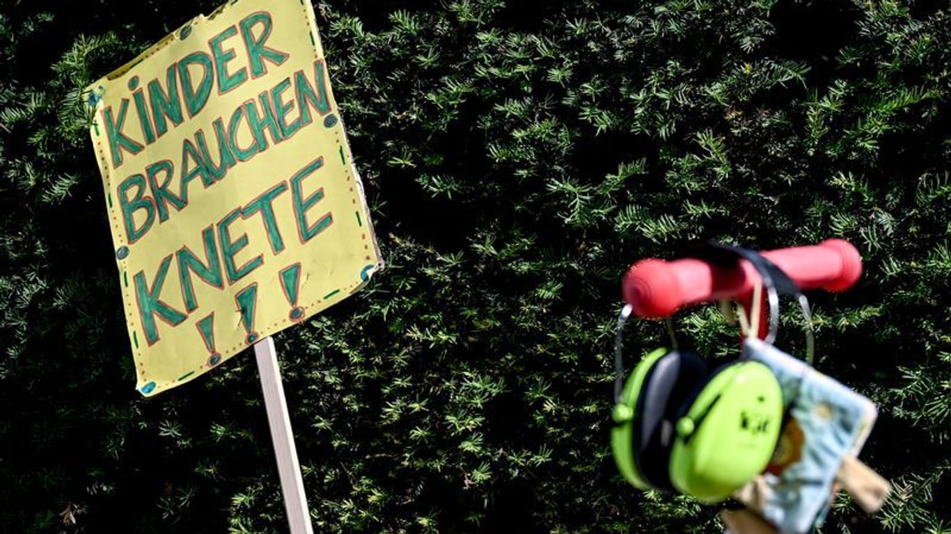 Vor dem Berliner Abgeordnetenhaus steht ein Schild mit der Aufschrift "Kinder brauchen Knete" bei der Kundgebung streikender Kita-Erzieherinnen