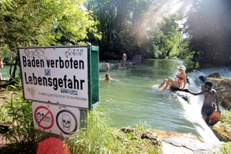 "Baden verboten" steht auf einem Schild am Eisbach (Archivbild): Dennoch gehen viele Menschen im Englischen Garten baden – und begeben sich damit in tödliche Gefahr.